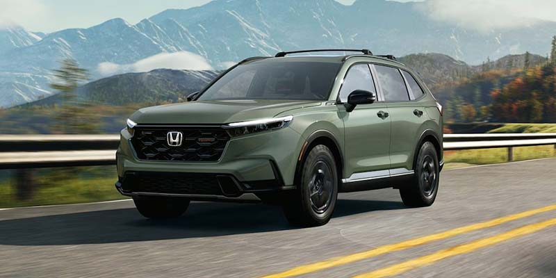 A green 2026 Honda CRV drives down a highway in Denver, CO