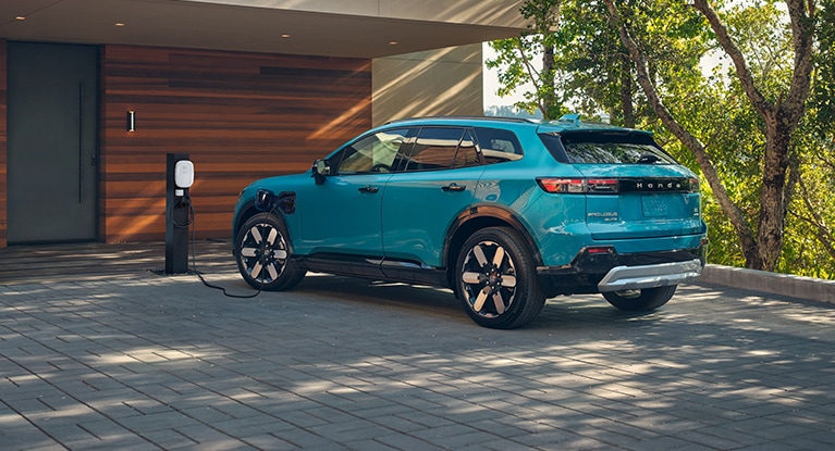 2026 Honada Prologue in Pacific Blue Metallic, plugged in and charging in a home driveway